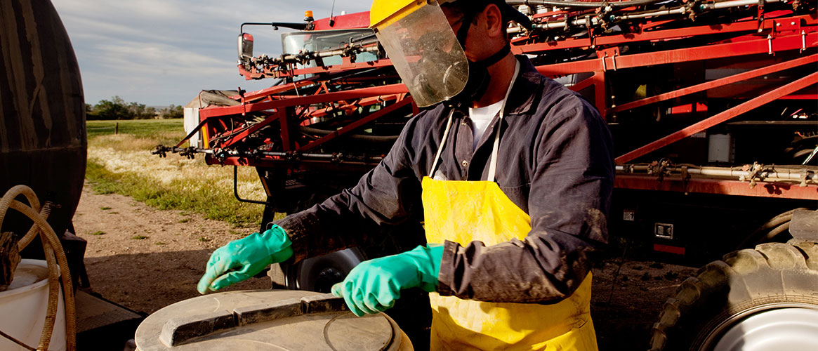 Outdoor worker wearing protective gear while getting ready to use corrosive material